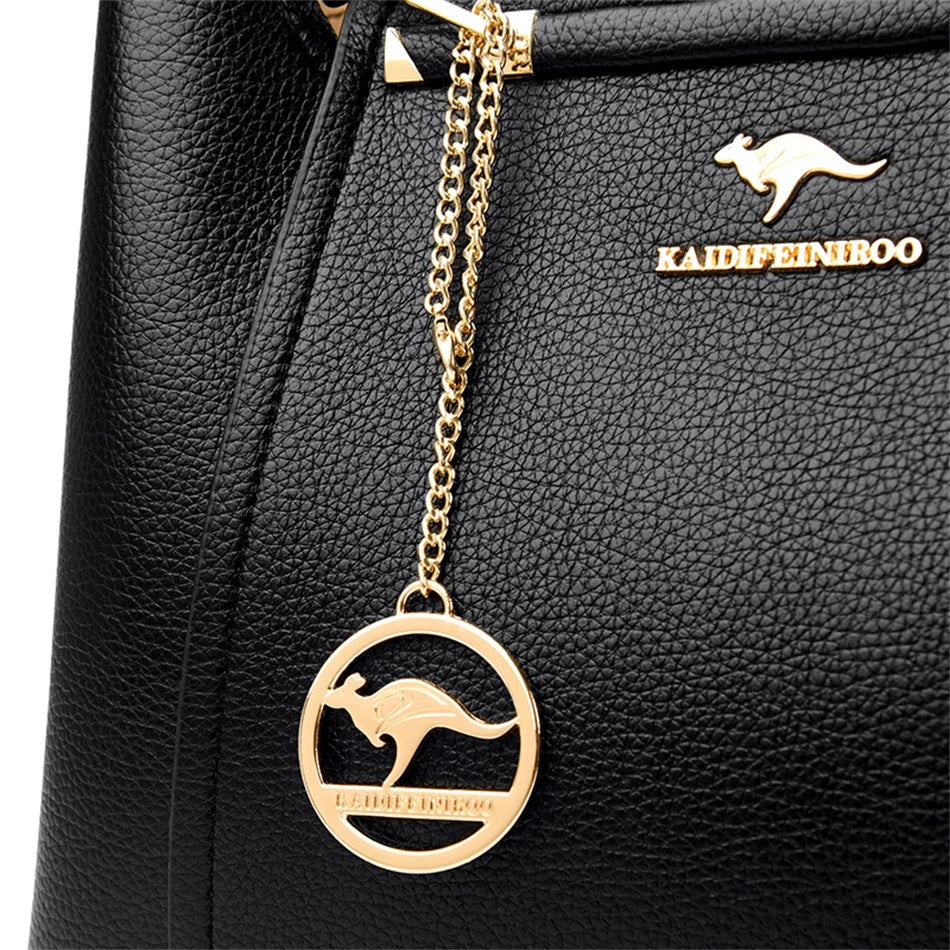 A stylish soft leather triple layer crossbody tote handbag with letter and kangaroo pendant decorations, perfect for women on the go.