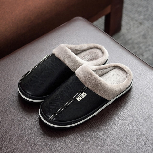 A pair of men's indoor slippers made of proportioned PU and plush insole material. The slippers are a light brown color and have a comfortable, relaxed design.