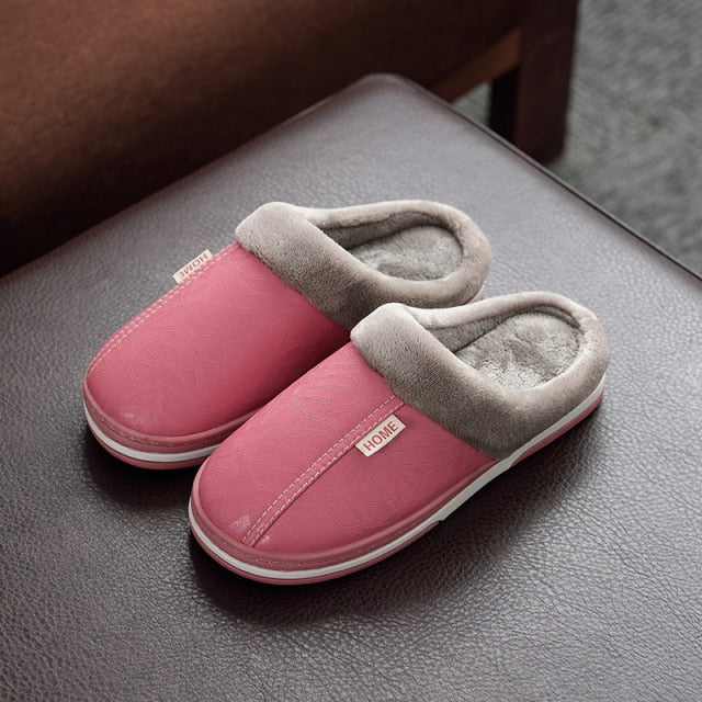 A pair of men's indoor slippers made of proportioned PU and plush insole material. The slippers are a light brown color and have a comfortable, relaxed design.