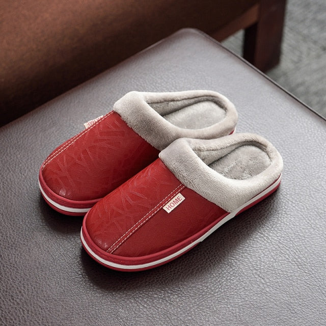 A pair of men's indoor slippers made of proportioned PU and plush insole material. The slippers are a light brown color and have a comfortable, relaxed design.