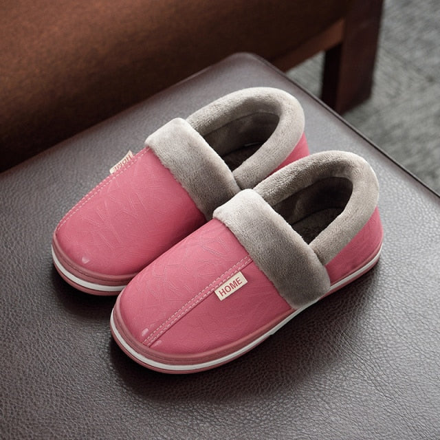 A pair of men's indoor slippers made of proportioned PU and plush insole material. The slippers are a light brown color and have a comfortable, relaxed design.