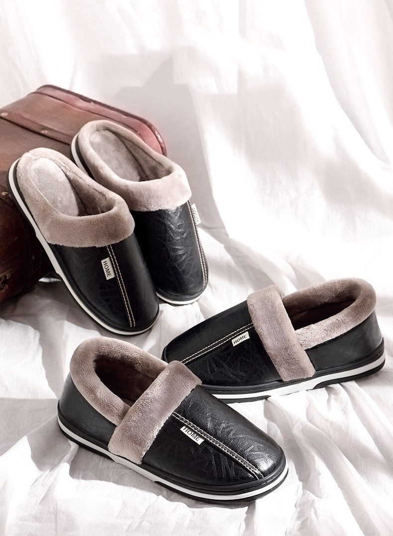 A pair of men's indoor slippers made of proportioned PU and plush insole material. The slippers are a light brown color and have a comfortable, relaxed design.