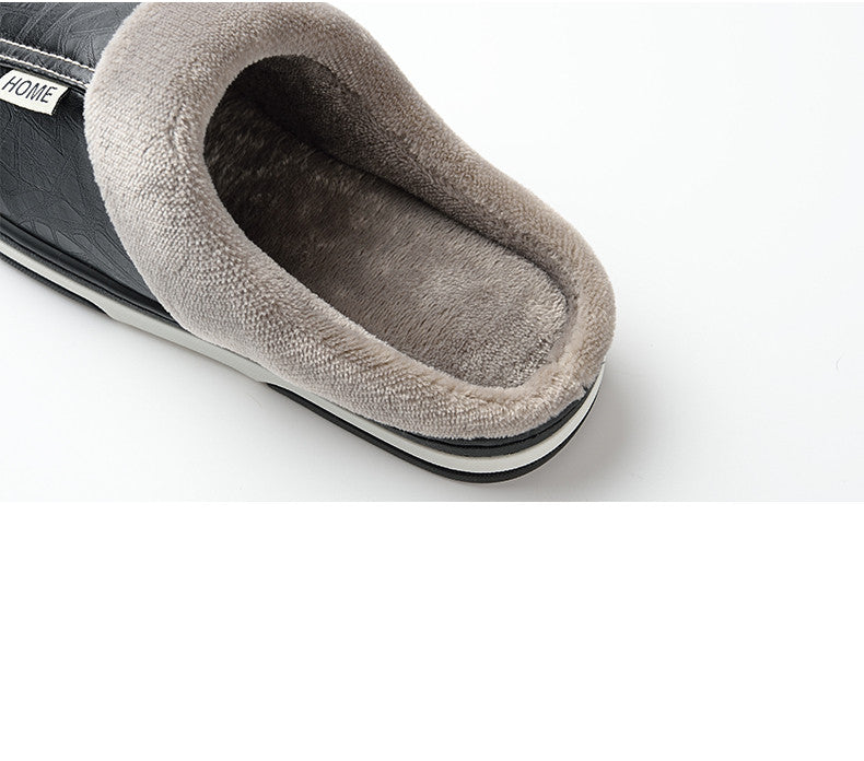 A pair of men's indoor slippers made of proportioned PU and plush insole material. The slippers are a light brown color and have a comfortable, relaxed design.