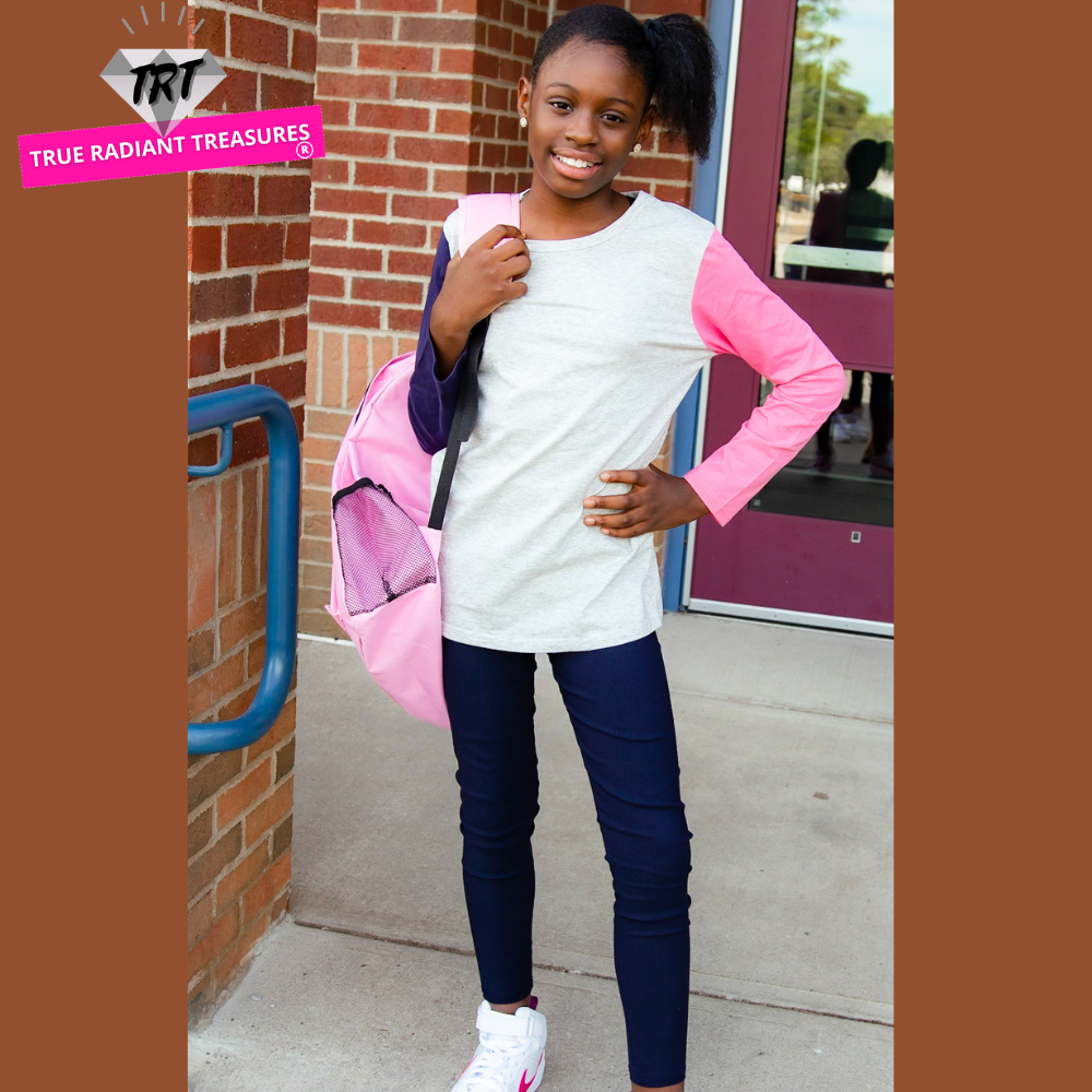 A young girl wearing a long sleeve shirt from True Radiant Treasures. The shirt is made from a soft polyester and cotton blend and comes in a variety of colors and patterns.