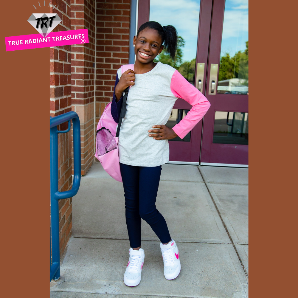 A young girl wearing a long sleeve shirt from True Radiant Treasures. The shirt is made from a soft polyester and cotton blend and comes in a variety of colors and patterns.