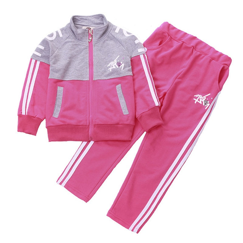 A young girl wearing a jacket and pants set. The jacket is made of a soft, comfortable material and the pants are made of a durable fabric. The set comes in a variety of colors and sizes to fit girls of all ages.