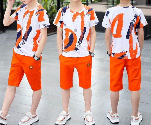 Image of a boy wearing a sports shirt and shorts in a fun design. Made from breathable cotton and polyester for comfort and durability during outdoor play and school sports activities.