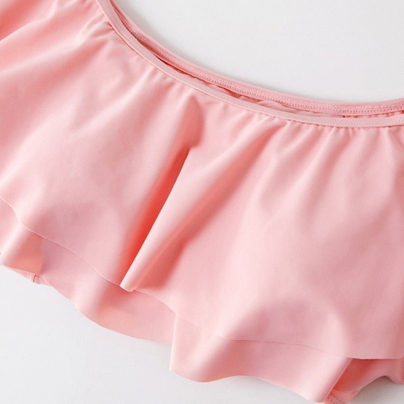 Image of Matching Pink Swimwear - Tropical-themed swimwear for the whole family. Made of comfortable polyester. Perfect for summer getaways and beach days. Get yours now and create unforgettable memories!