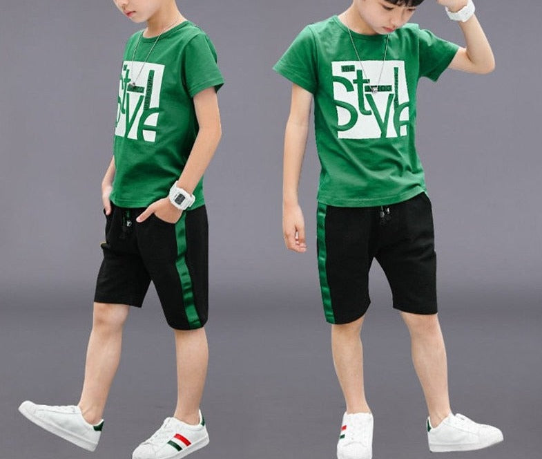 Image of a boy wearing a sports shirt and shorts in a fun design. Made from breathable cotton and polyester for comfort and durability during outdoor play and school sports activities.