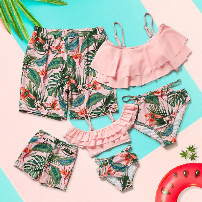 Image of Matching Pink Swimwear - Tropical-themed swimwear for the whole family. Made of comfortable polyester. Perfect for summer getaways and beach days. Get yours now and create unforgettable memories!