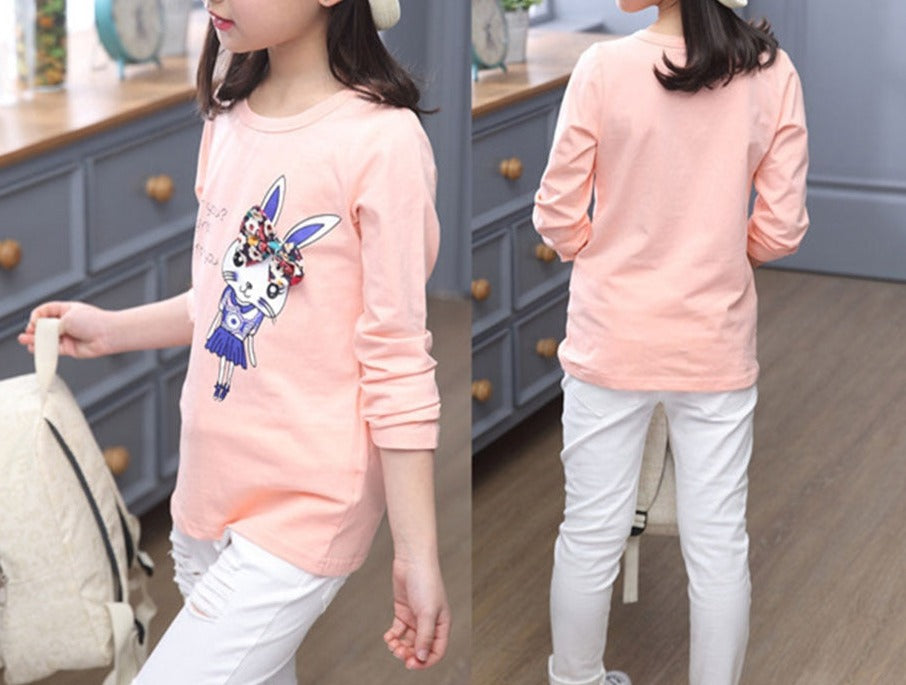 A young girl wearing a long sleeve shirt from True Radiant Treasures. The shirt is made from a soft polyester and cotton blend and comes in a variety of colors and patterns.